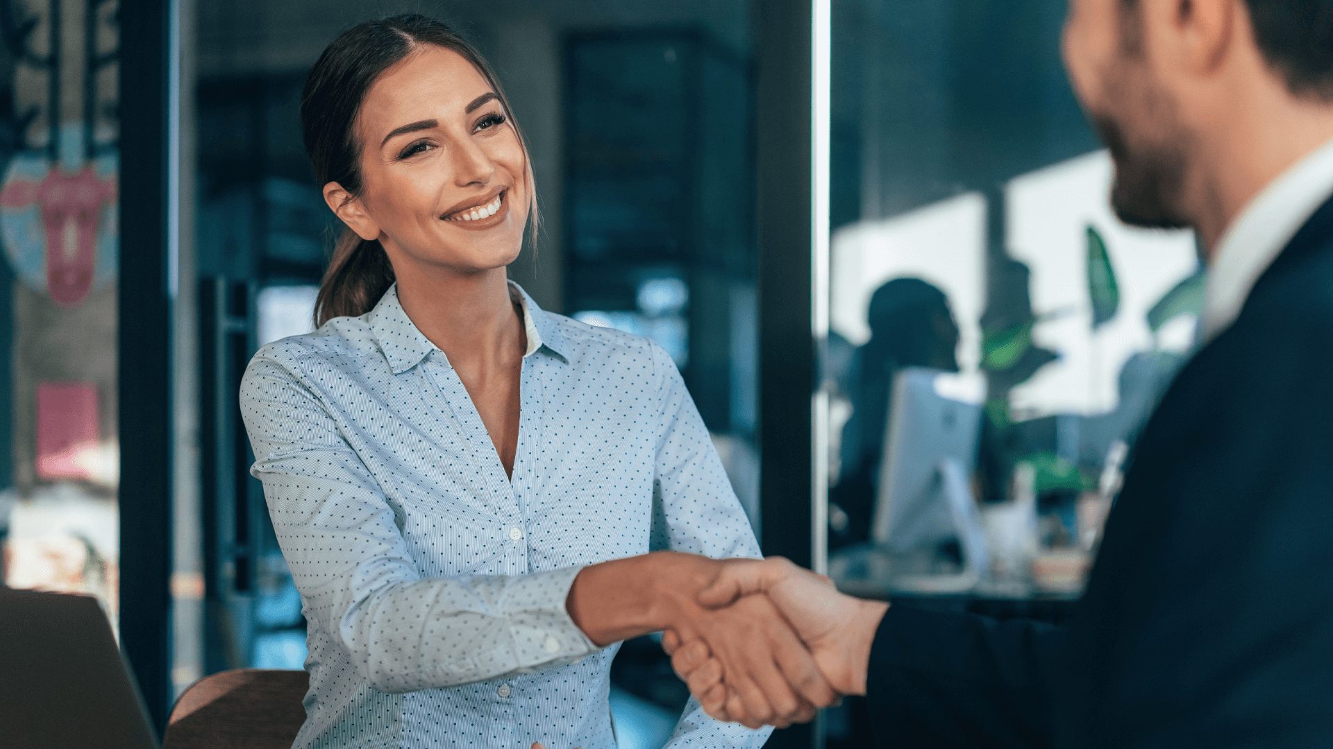 Duas pessoas em um ambiente corporativo cumprimentando-se